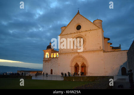 Fassade der Basilika von San Francesco in der Dämmerung in einem bewölkten Tag, Assisi, Umbrien, Italien. Stockfoto