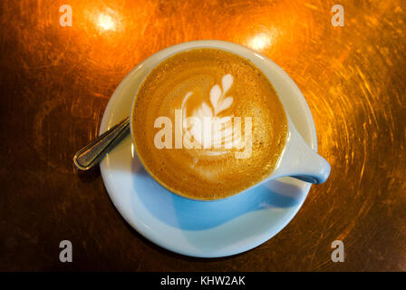 Milchdesign schwimmt auf einem Cappuccino in einer weißen Tasse Stockfoto