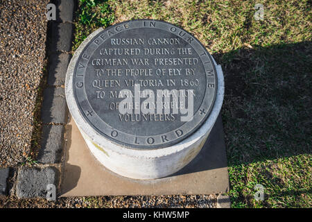 Ely Cannon, Tafel mit Widmung neben einer gefangenen russischen Kanone aus dem Krimkrieg in der Cathedral Green, Ely, Cambridgeshire, Großbritannien. Stockfoto