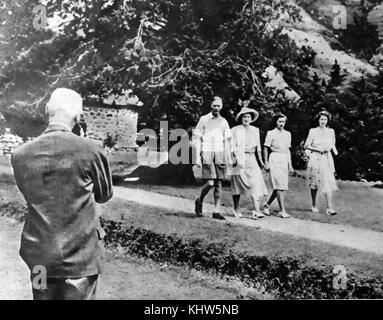 Foto von König George VI mit seiner Frau und zwei Töchtern, Prinzessin Margaret (rechts) und Prinzessin Elizabeth (), während Jan Smuts nimmt eine Cine Datensatz in Südafrika. George VI (1895-1952) König von Großbritannien und die Dominions des British Commonwealth, der letzte Kaiser von Indien und der erste Leiter des Commonwealth. Königin Elizabeth, die Königinmutter (1900-2002). Prinzessin Margaret, Countess von Snowdon (1930-2002). Prinzessin Elizabeth (1926-) Königin von Großbritannien, Kanada, Australien und Neuseeland. Feldmarschall Jan Christiaan Smuts (1870-1950). Stockfoto