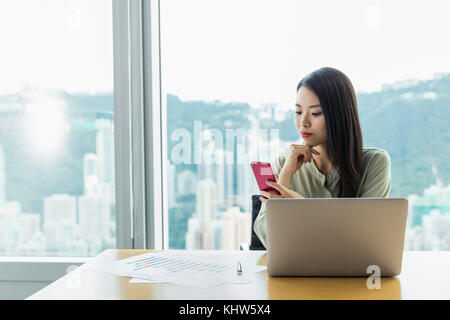 Geschäftsfrau mit Laptop und Smartphone Stockfoto