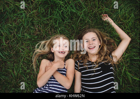 Overhead Portrait von Mädchen und ihre Schwester liegen auf Gras Stockfoto
