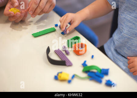 Vater und Sohn, am Tisch sitzen, spielen mit Knetmasse, close-up Stockfoto