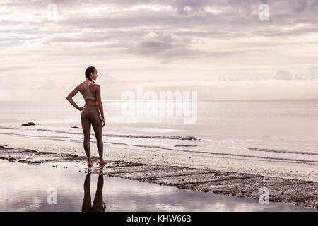 Junge Läuferin an der Wasserkante mit Blick auf das Meer Stockfoto