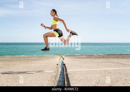 Junge Frau läuft im Freien, über Lücke in der Brücke springen, der Luft Stockfoto