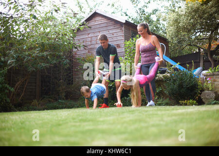 Familie im Garten, in schubkarrenrennen Stockfoto