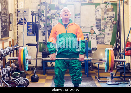 Ältere männliche Powerlifter kämpfen Barbell in der Turnhalle zu heben Stockfoto