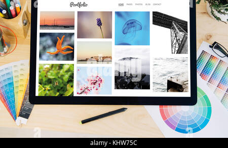 Tablet pro Touchscreen auf dem Desktop mit kreativen Foto Portfolio auf dem Bildschirm Stockfoto