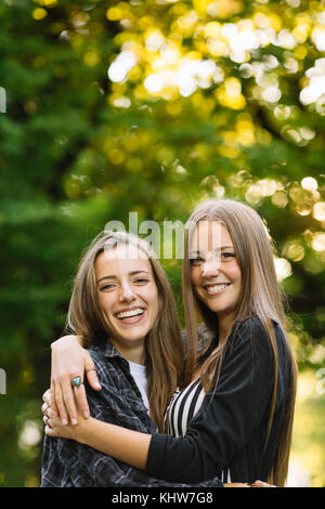 Porträt von zwei Junge weibliche Freunde umarmen in Park Stockfoto