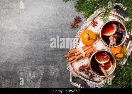 Weihnachten Glühwein mit Gewürzen in Kupfer cups auf dunklem Hintergrund. Ansicht von oben mit der Kopie Raum Stockfoto