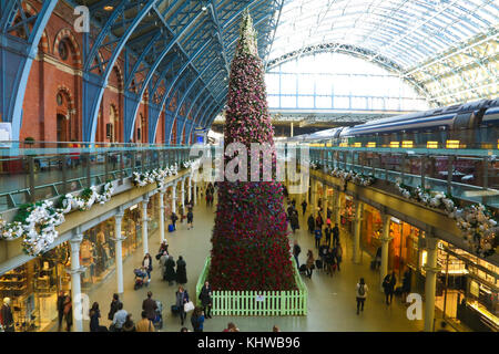 Internationalen Bahnhof St. Pancras. London, UK. 19 Nov, 2017. Pendler hinter den 47 Fuß floral Weihnachtsbaum am internationalen Bahnhof St. Pancras in London. Entworfen von Floristen moyses Stevens, der Baum, die von über 15.000 Blumen. Äste des Baumes mit Rosen interlaced sind; Hortensien; zarte Anemonen; Orchideen und Dianthus, Amaryllis, während die Blütenblätter und Tannenzapfen Quersaiten werden um den Baum statt twinkly leuchtet. Credit: dinendra Haria/alamy leben Nachrichten Stockfoto