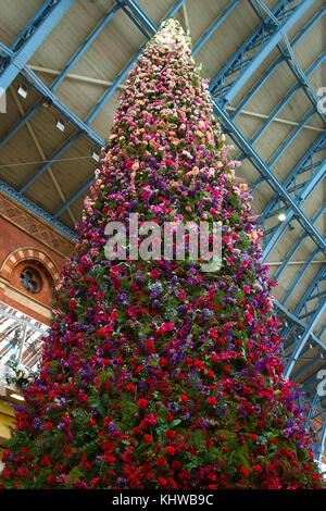 Internationalen Bahnhof St. Pancras. London, UK. 19 Nov, 2017. Pendler hinter den 47 Fuß floral Weihnachtsbaum am internationalen Bahnhof St. Pancras in London. Entworfen von Floristen moyses Stevens, der Baum, die von über 15.000 Blumen. Äste des Baumes mit Rosen interlaced sind; Hortensien; zarte Anemonen; Orchideen und Dianthus, Amaryllis, während die Blütenblätter und Tannenzapfen Quersaiten werden um den Baum statt twinkly leuchtet. Credit: dinendra Haria/alamy leben Nachrichten Stockfoto