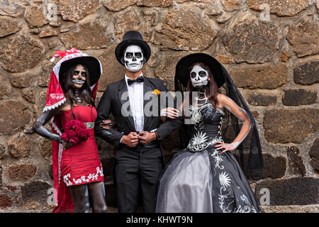 Mexikanische Teenager in La Calavera Catrina und Dapper Skelett Kostüme für den Tag der Toten oder Día de Muertos Festival 31. Oktober 2017 in Patzcuaro, Michoacan, Mexiko gekleidet. Das Fest wird seit dem aztekischen Reich gefeiert feiert Vorfahren und verstorbene Lieben. Stockfoto