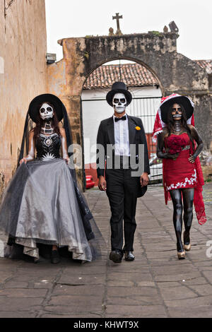 Mexikanische Teenager in La Calavera Catrina und Dapper Skelett Kostüme für den Tag der Toten oder Día de Muertos Festival 31. Oktober 2017 in Patzcuaro, Michoacan, Mexiko gekleidet. Das Fest wird seit dem aztekischen Reich gefeiert feiert Vorfahren und verstorbene Lieben. Stockfoto