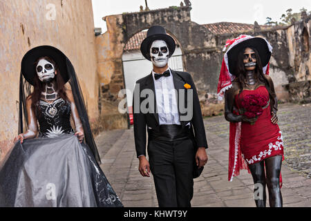 Mexikanische Teenager in La Calavera Catrina und Dapper Skelett Kostüme für den Tag der Toten oder Día de Muertos Festival 31. Oktober 2017 in Patzcuaro, Michoacan, Mexiko gekleidet. Das Fest wird seit dem aztekischen Reich gefeiert feiert Vorfahren und verstorbene Lieben. Stockfoto