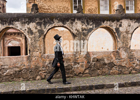 Ein Mexikaner, der als Dapper Skelett gekleidet ist, geht am Día. Oktober 2017 am Templo del Sagrario am Tag der Toten oder am 31 de Muertos-Festival in Patzcuaro, Michoacan, Mexiko vorbei. Das Fest wird seit dem aztekischen Reich gefeiert feiert Vorfahren und verstorbene Lieben. Stockfoto