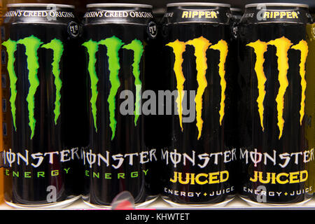 Dosen von Monster Energy Drinks auf Anzeige auf Verkauf auf einem Regal im Supermarkt zu speichern. Stockfoto