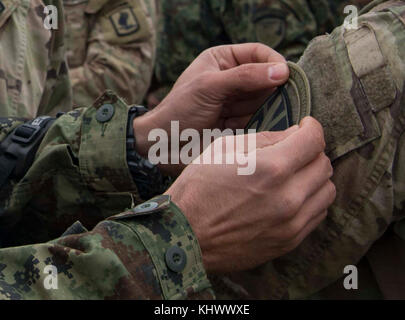 Eine serbische Fallschirmjäger trades Schulter Patches mit einem U.S. Army Fallschirmjäger auf die 173Rd Airborne Brigade auf Lisicji Jarak Flughafen, Serbien, Nov. 17, 2017 zugeordnet. Usa und Serbischen Fallschirmjäger durchgeführt Airborne insertion Übungen zusammen, die während der Übung Doppeladler, voneinander zu lernen und Beziehungen aufzubauen, dass die regionale Sicherheit zu fördern. (U.S. Air Force Foto von älteren Flieger Elizabeth Baker) Stockfoto