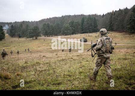 Us-Soldaten vom 2. Bataillon, 70. Armor Regiment, 2. gepanzerte Brigade Combat Team, 1.Infanterie Division in Fort Riley, Kansas März zu einem Baum Leitung auf einem fiktiven Feindes-kontrollierten Dorf während eines alliierten Geist VII Schulungsveranstaltung am 07.11.18, in Grafenwöhr, Deutschland 2017. Die US-Armee, zusammen mit seinen Verbündeten und Partnern, weiterhin eine dynamische Präsenz mit einem leistungsstarken Land Netzwerk, die gleichzeitig Aggression abhält und sorgt für die Sicherheit der Region zu schmieden. Service rund 3.700 Mitglieder aus 13 Nationen in 7. Armee den Befehl Hohenfels Training Bereich gesammelt Stockfoto