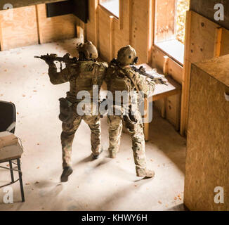 Zwei grüne Barette auf das erste Bataillon zugeordnet, 10 Special Forces Group (Airborne), klar ein Zimmer während eines Special Forces erweiterte Häuserkampf (SFAUC) Training in der Nähe von Stuttgart, Deutschland, 16. November, 2017. Die SFAUC Übung testet die Grünhelme' Fähigkeit, direkte Aktion Streiks in städtischen Gebieten zu führen. Häuserkampf ist ein Skill 10 Gruppe regelmäßig Züge mit multinationalen Special Operations Partner. (U.S. Armee Foto von SPC. Christopher Stevenson) Stockfoto