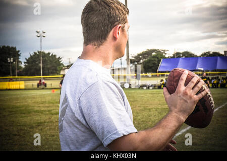 Ein US Air Force service Mitglieder bereitet ein Fußball während der jährlichen Türkei Schüssel im Soto Cano Air Base, Honduras, Nov. 16, 2017 zu werfen. Die Veranstaltung bye der Moral, Wohlfahrt und Erholung Team endete mit der Luftwaffe die gewinnen. Der Fall kennzeichnete auch die Hälfte der Zeit zeigen, indem Sie eine lokale marching band. (U.S. Armee Foto von Maria Pinel) Stockfoto