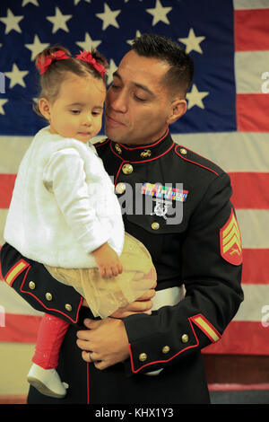 MONTROSE, CO - Marine Corps veteran Sgt. Eubaldo Lovato, ein silberner Stern Empfänger, hält seine Tochter vor seiner Silver Star Preisverleihung in Montrose, Colo., Nov. 18, 2017. Lovato erhielten eine Auszeichnung, von seinem früheren Bronze Star, für seinen heldenhaften Aktionen während als Truppführer mit Firma A, 1st Battalion, 14th Marine Regiment, 1st Marine Division, während des Betriebs Al Fadschr, Teil der Operation Iraqi Freedom, an November 15, 2004. Der Silver Star ist der United States Third - höchste persönliche Auszeichnung für Tapferkeit im Kampf. (U.S. Marine Corps Foto von Pfc. Samantha Schwoch/Freigegeben) Stockfoto