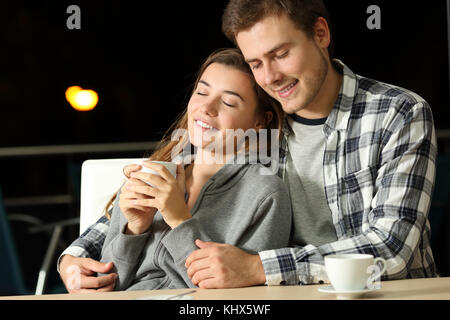 Enamored paar Jugendliche dating in einer Bar in der Nacht Stockfoto