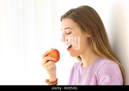 Portrait Of Happy Teen das Essen eines Apfels auf Weiß an der Seite isoliert Stockfoto