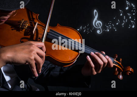 Nahaufnahme Geiger in dunklen Studio mit Noten, musikalische Konzept Stockfoto