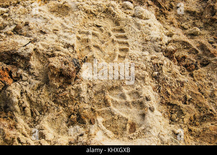 Impressum In eines Mannes Fuß in den Schuhen auf dem nassen Sand Stockfoto