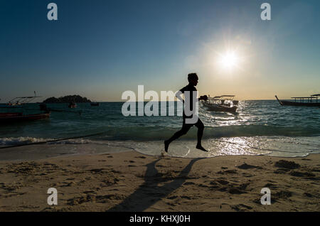Silhouette bei Sonnenaufgang Laufzeit über das Meer Strand mit Lens flare Stockfoto