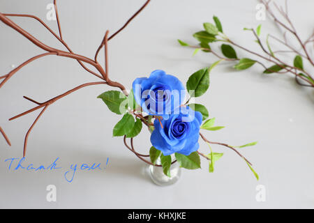 Danke Hintergrund mit dankbar Nachricht, zwei blaue Rosen mit grünen Blatt aus Ton Kunst auf weißem Hintergrund, Karte für Lehrer Tag, Muttertag Stockfoto