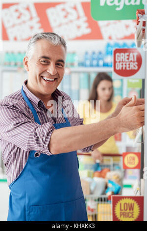 Professionelle Supermarkt Sekretärin in der store Gang arbeiten, er ist das Sortieren Elemente auf dem Regal Stockfoto