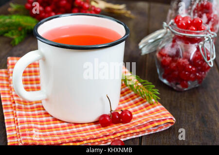 Hot Berry Tee in eine weiße Tasse auf einem dunklen Hintergrund. Tee mit viburnum. Beeren mit Zucker in einem Glas. therapeutische trinken. Stockfoto