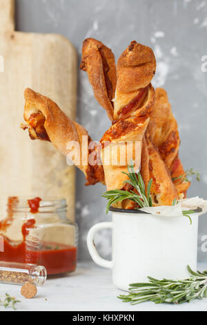 Leckere Käsestange mit Speck, Kräuter und Tomatensauce. Fleisch Käse Snack für Bier, party Konzept, Tag Thanksgiving. Stockfoto