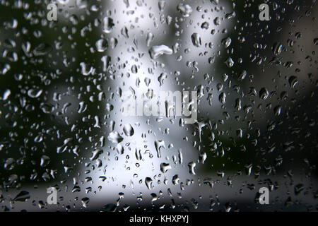 Tropfen Wasser regnet auf einer Fensterscheibe. Stockfoto