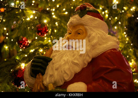 Santa claus am Kölner Dom Weihnachtsmarkt mit Beleuchteter Christbaum im Hintergrund. Stockfoto