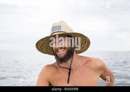 Mann im Wasser, tragen, Stroh, Hut, Lachen Stockfoto
