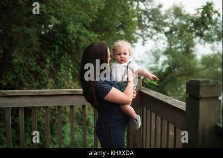 Schwangere Frau mit Kleinkind Sohn auf dem Balkon Stockfoto