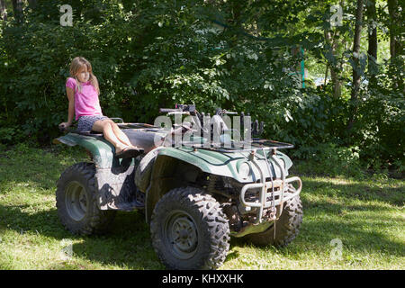 Junges Mädchen sitzt auf dem Quad Stockfoto