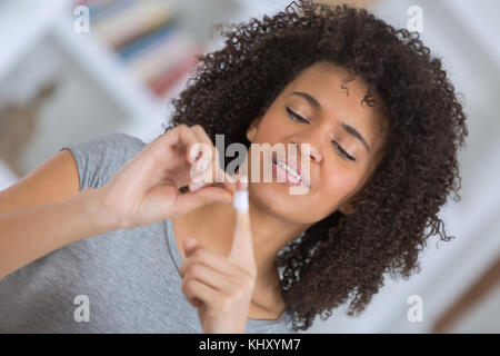 schöne Frau setzt Klebeband an ihrem finger Stockfoto