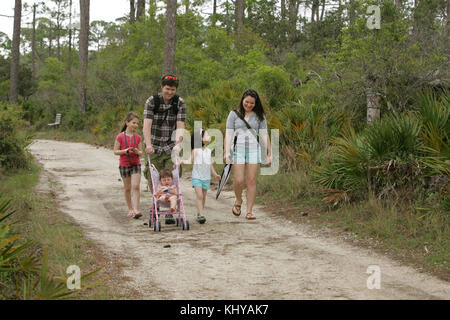 Dieses Bild zeigt eine Familie, die einen gemütlichen Spaziergang entlang der Pfade in einem Park genießt. Die friedliche Umgebung spiegelt die Schönheit der Natur und die Bedeutung von Outdoor-Aktivitäten für Familien wider. Stockfoto