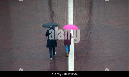 Potsdam, Deutschland. November 2017. Zwei Kinderwagen auf der anderen Straßenseite mit Regenschirmen bei Regen in Potsdam, Deutschland, 21. November 2017. Quelle: Ralf Hirschberger/dpa-Zentralbild/ZB/dpa/Alamy Live News Stockfoto