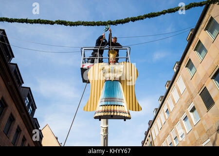 Nürnberg, Deutschland. November 2017. Arbeiter befestigen den restaurierten Lametta-Engel „Baerbel“ am Eingang des Christkindlesmarktes in Nürnberg, Deutschland, 22. November 2017. Insgesamt wurden drei Lametta-Engel in etwa sechs Monaten vollständig restauriert. Vermerk: Daniel Karmann/dpa/Alamy Live News Stockfoto