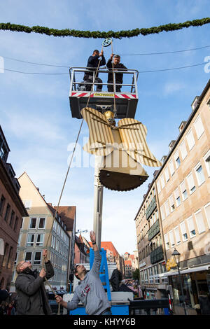 Nürnberg, Deutschland. November 2017. Arbeiter befestigen den restaurierten Lametta-Engel „Baerbel“ am Eingang des Christkindlesmarktes in Nürnberg, Deutschland, 22. November 2017. Insgesamt wurden drei Lametta-Engel in etwa sechs Monaten vollständig restauriert. Vermerk: Daniel Karmann/dpa/Alamy Live News Stockfoto