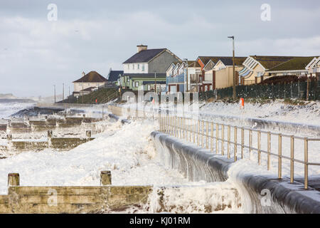 Tywyn, Großbritannien. 23 Nov, 2017. de Wetter. Starke Winde und große Wellen lassen Sie eine Schicht von Sea Foam für die Prom in tywyn macht es den Anschein, dass es schneit wurde. Quelle: Jon Freeman/alamy leben Nachrichten Stockfoto