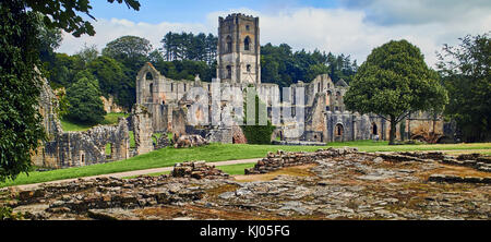 England, NorthYorkshire; die Ruinen des 12. Jahrhunderts Zisterzienserabtei als Fountains Abbey, eines der schönsten Beispiele der klösterlichen Architektur in der Welt bekannt. Der Turm von Abt Huby, (1495-1526), dominiert das Tal noch Landschaft. Zusammen mit seinen umliegenden 800 Morgen des 18.Jahrhunderts angelegten Parklandschaft, Fountains Abbey wurde von der UNESCO zum Weltkulturerbe ernannt. North Yorkshire, England, UK. Ca. 1995. | Lage: in der Nähe von Bedale, Yorkshire, England, UK. Stockfoto