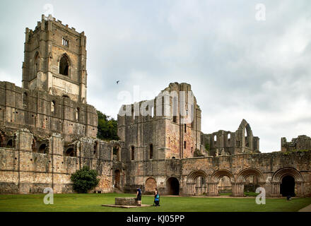 England, NorthYorkshire; die Ruinen des 12. Jahrhunderts Zisterzienserabtei als Fountains Abbey, eines der schönsten Beispiele der klösterlichen Architektur in der Welt bekannt. Der Turm von Abt Huby, (1495-1526), dominiert das Tal noch Landschaft. Zusammen mit seinen umliegenden 800 Morgen des 18.Jahrhunderts angelegten Parklandschaft, Fountains Abbey wurde von der UNESCO zum Weltkulturerbe ernannt. North Yorkshire, England, UK. Ca. 1995. | Lage: in der Nähe von Bedale, Yorkshire, England, UK. Stockfoto