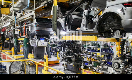 Arbeitnehmer auf Motor-Produktionslinie in Automobilfabrik Stockfoto