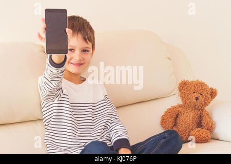 Little Boy show Zelle smart phone Bildschirm mit leeren Platz kopieren Stockfoto